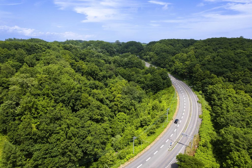 十勝平野に広がる一本道と青空、車窓から見えるドライブ風景
