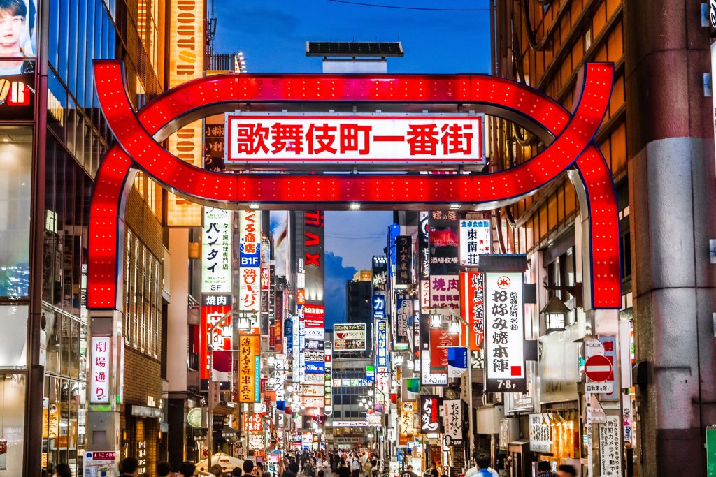歌舞伎町のネオンサインと賑わう夜の繁華街